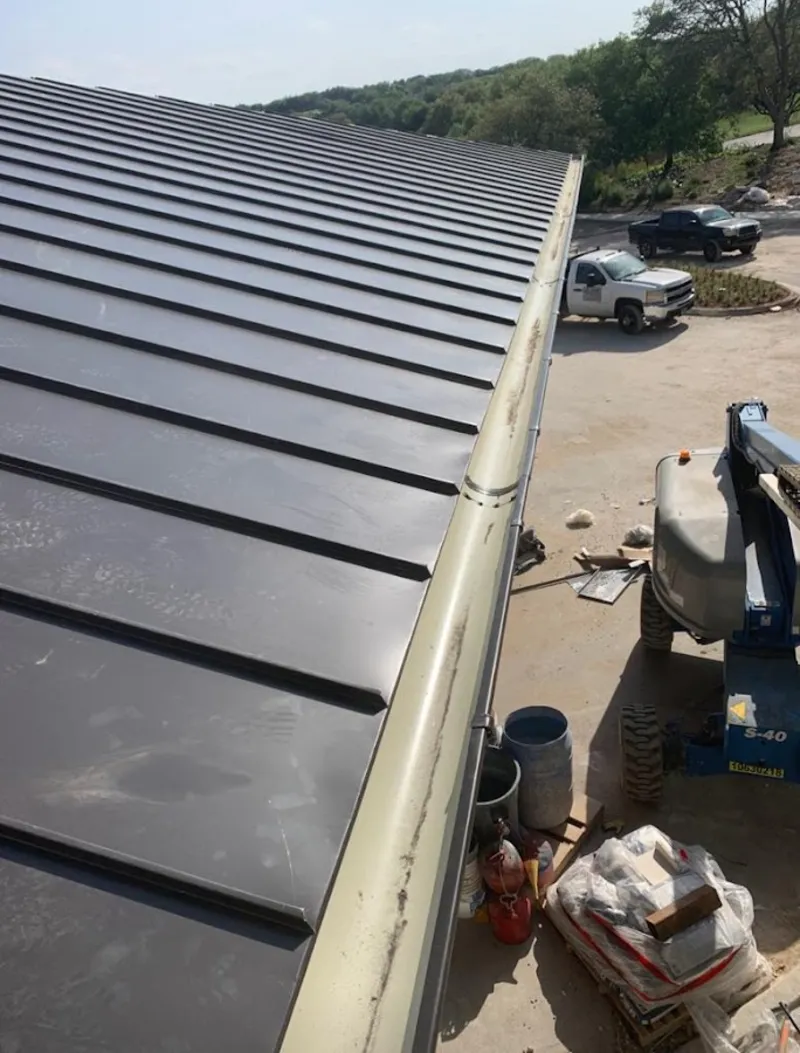 Standing seam panel and gutter detail on a metal roofing jobsite in Laketon